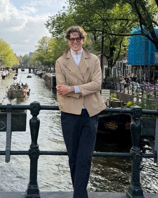 Jon Binzegger lächelnd auf einer Brücke an einer Gracht